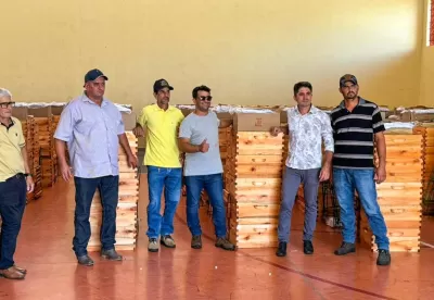Produtores rurais posam para foto ao lado de kits de apicultura