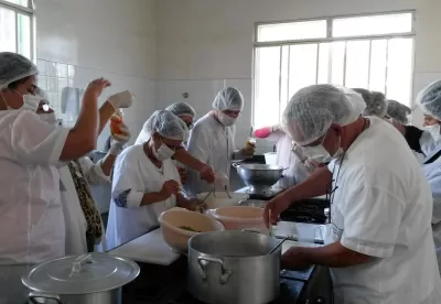 mulheres estão na imagem mexendo com utensílios para realizar refeição