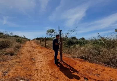 homem no centro da imagem fazendo georreferenciamento do espaço numa estrada de terra