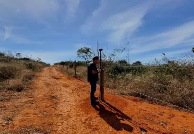 homem no centro da imagem mexendo em seu equipamento no meio de uma estrada de terra