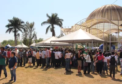 pessoas em pé ao redor de barracas ao fundo da imagem