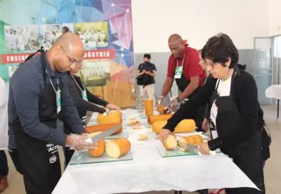 queijos expostos em cima da mesa sendo cortados