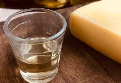 Foto de copo cachaça ao lado de um queijo