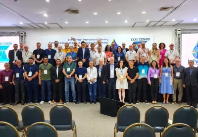 homens e mulheres em pé fazendo duas filas, uma em cima do palco e outra logo abaixo