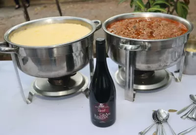 dois recipientes com comida e o vinho no centro da imagem