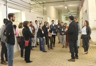 pessoas em pé ouvindo um palestrante falando