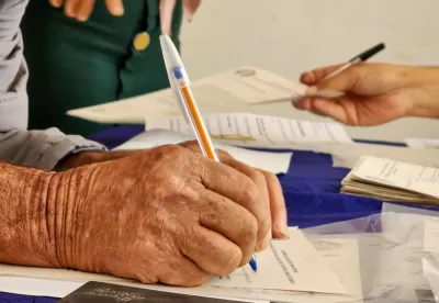 Mão assinando documento