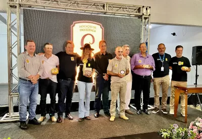 Foto mostra Secretário Thales Fernandes e os produtores segurando o Queijo Minas Artesanal do Serro com o Selo de Indicação Geográfica na embalagem