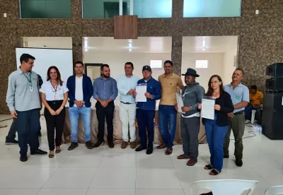 Foto mostra agricultores familiares de Rio Pardo de Minas segurando seus títulos de propriedade rural entregues pelo Governo de Minas