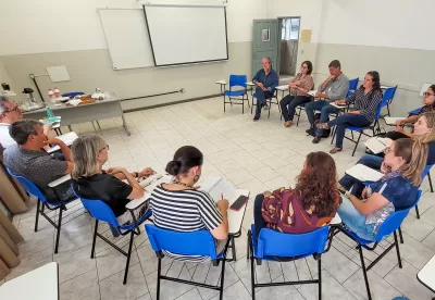 Pessoas reunidas em um semi-círculo em uma sala