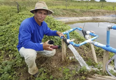 Produtor rural ao lado de técnica de irrigação de salvamento