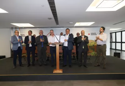 Foto mostra governador Romeu Zema e secretário de Agricultura Thales Fernandes segurando acordo assinado com municípios para o início do programa de regularização fundiária