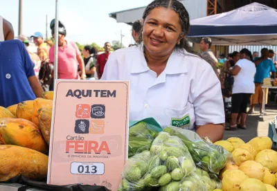 mulher segura cartão de feira atrás de sua mesa