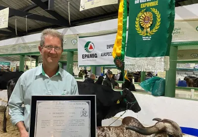 Foto mostra a pesquisador da Epamig ao lado da vaca premiada com a premiação