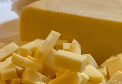 metade de queijo inteiro e a outra metade cortado em cubos para degustação.