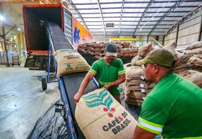 saca de café sendo colocada no caminhão