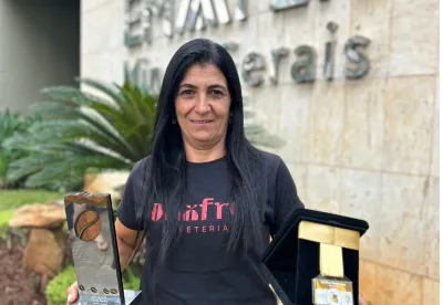 Produtora segura seus troféus em frente à fachada da Emater