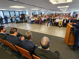secretário thales fernandes discursando durante evento de doação de fertilzantes da harsco com público ao fundo