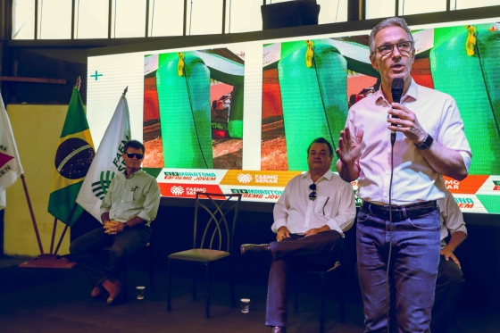 governador romeu zema discursando durante maratona faemg jovem com secretário thales fernandes e antonio de salvo sentados ao fundo