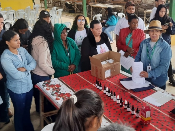 pessoas em pé ao redor de uma mesa com medicamentos