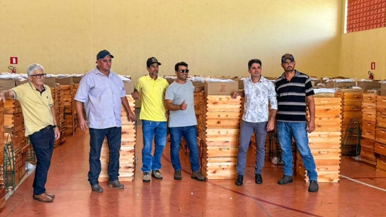 Produtores rurais posam para foto ao lado de kits de apicultura