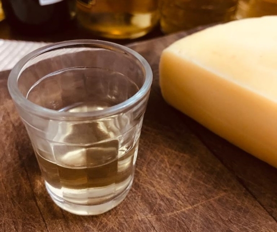 Foto de copo cachaça ao lado de um queijo