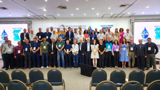 homens e mulheres em pé fazendo duas filas, uma em cima do palco e outra logo abaixo
