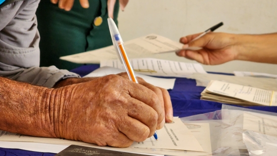 Mão assinando documento 