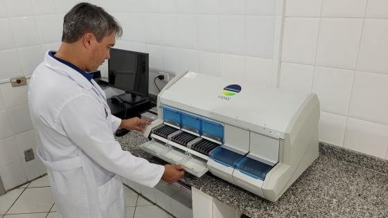 pesquisador da epamig de pé olhando para o imunoanalisador Vidas 30 sobre um balcão de granito ao lado de um computador no laboratório do instituto de laticínios candido tostes