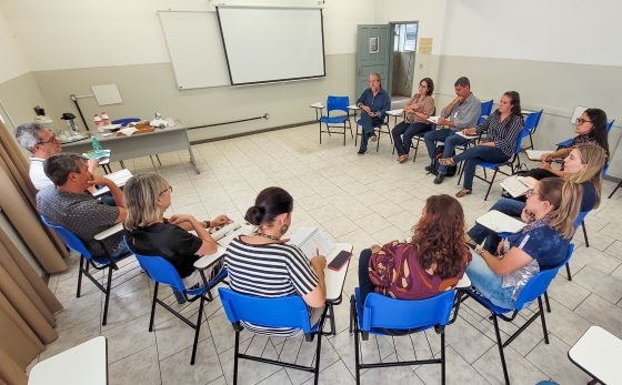Pessoas reunidas em um semi-círculo em uma sala