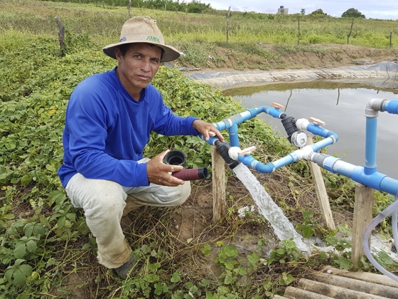 Produtor rural ao lado de técnica de irrigação de salvamento