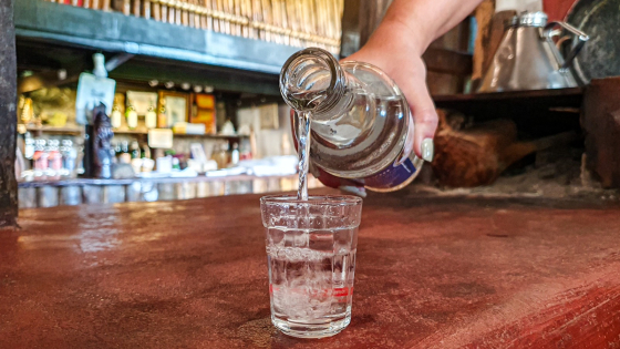 Foto mostra cachaça de alambique sendo virada no copo