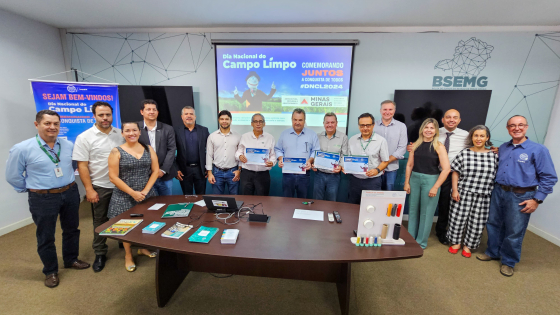 Autoridades enfileiradas seguram placa de reconhecimento 