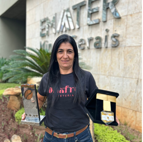 Produtora segura seus troféus em frente à fachada da Emater